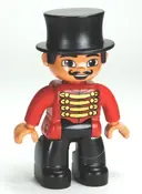Minifigurka: 47394PB152:  Duplo Figure Lego Ville, Male Circus Ringmaster, Black Legs, Red Top with Gold Braid, Top Hat, Brown Eyes (6023824)