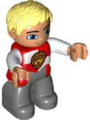 Minifigurka: 47394PB196:  Duplo Figure Lego Ville, Male Castle, Dark Bluish Gray Legs, Red and White Chest with Lion on Shield, Bright Light Yellow Hair, Blue Eyes