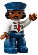 Minifigurka: 47394PB320:  Duplo Figure Lego Ville, Female Pilot, Dark Blue Legs, White Top with Red Tie, Dark Blue Hat with Black Hair (6361060)